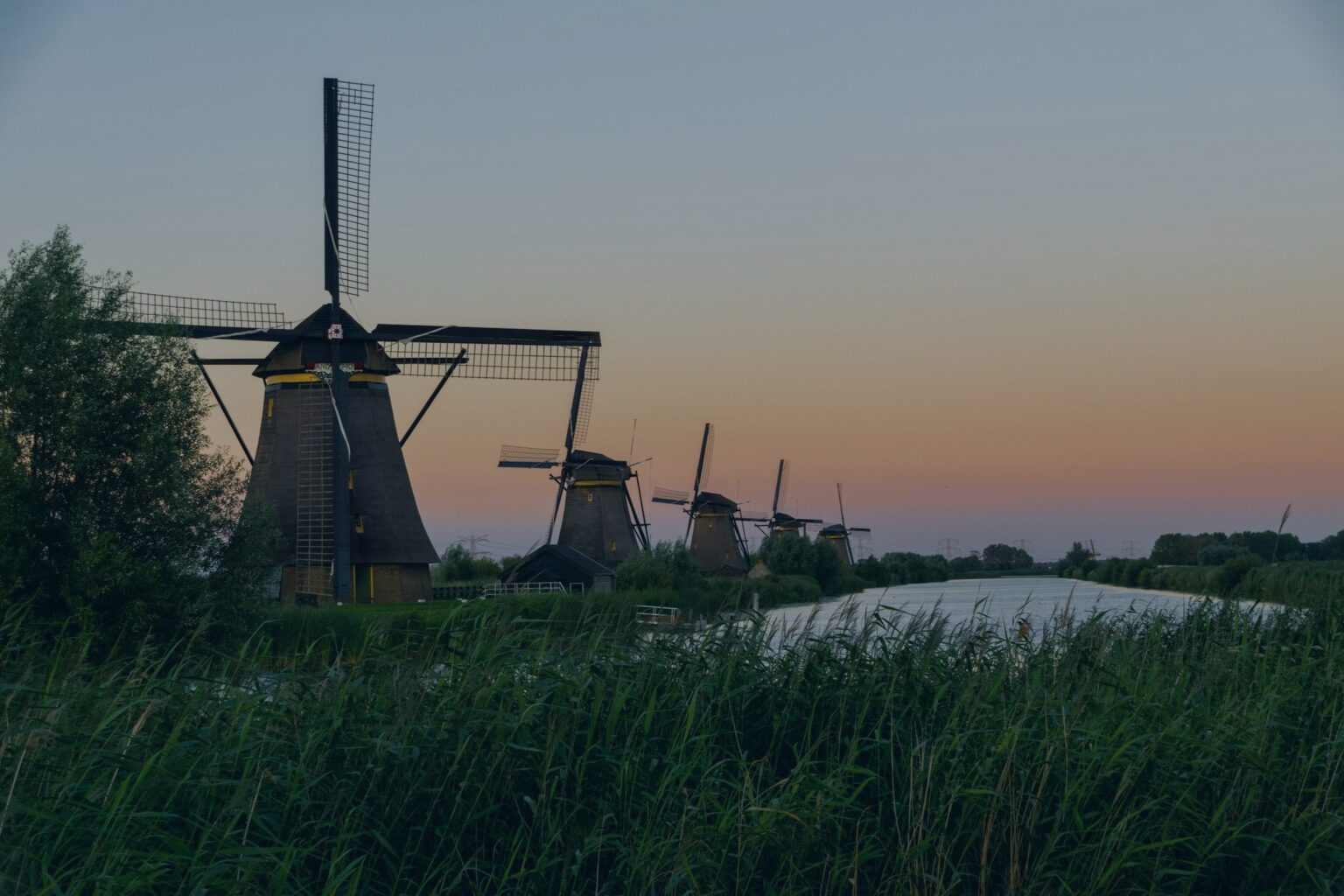 Molens in het Nederlandse landschap bij zonsondergang